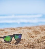 imagem de uma praia e um óculos de sol
